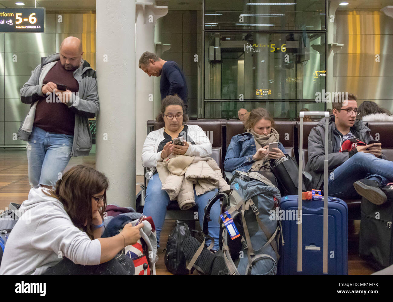 Les gens dans la salle d'attente de l'Eurostar de St Pancras, Londres, Angleterre, tous à l'aide de leur téléphone mobile Banque D'Images