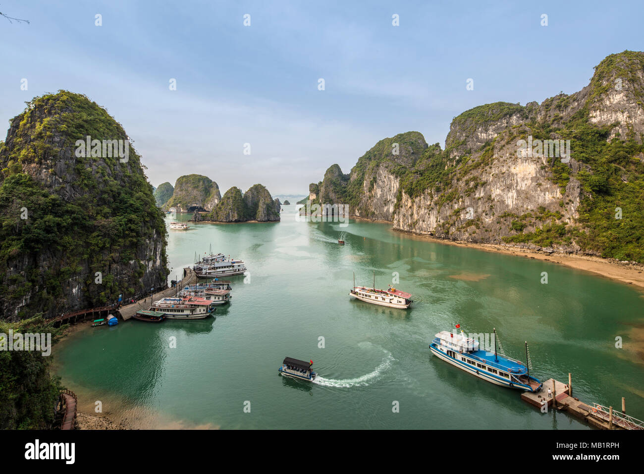 Vue panoramique spectaculaire de la Baie d'Ha Long, au nord-est de Vietnam avec eaux vert émeraude et d'imposants bateaux indésirable calcaire et en kayak de mer, Banque D'Images