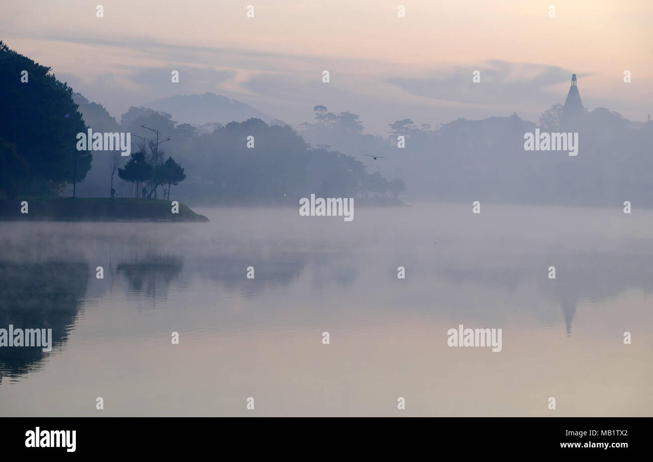 Paysage du collège pédagogique de Da Lat vue du lac de Xuan Huong, beau paysage refléter sur l'eau, clocher montée à partir de la forêt de pins Banque D'Images