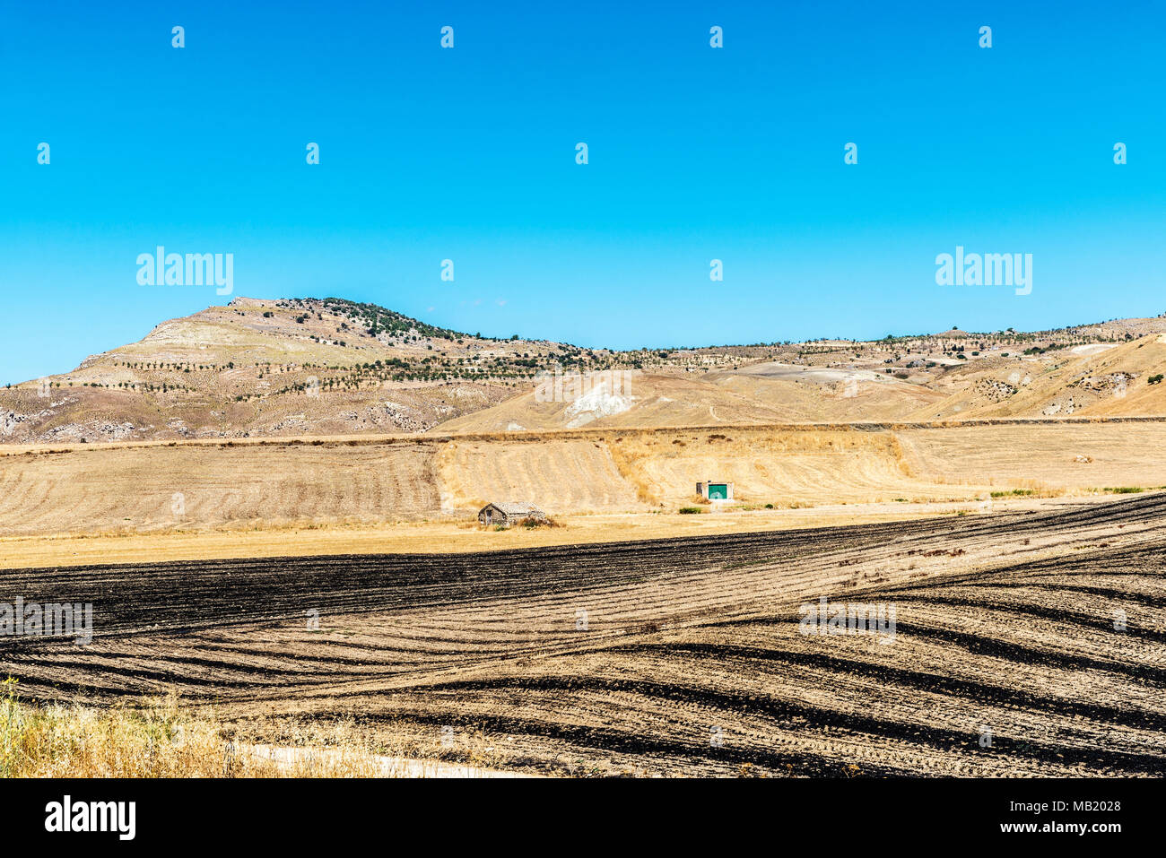 La terre sèche et de champs de blé brûlés après la récolte dans l'intérieur de la Sicile, Italie Banque D'Images