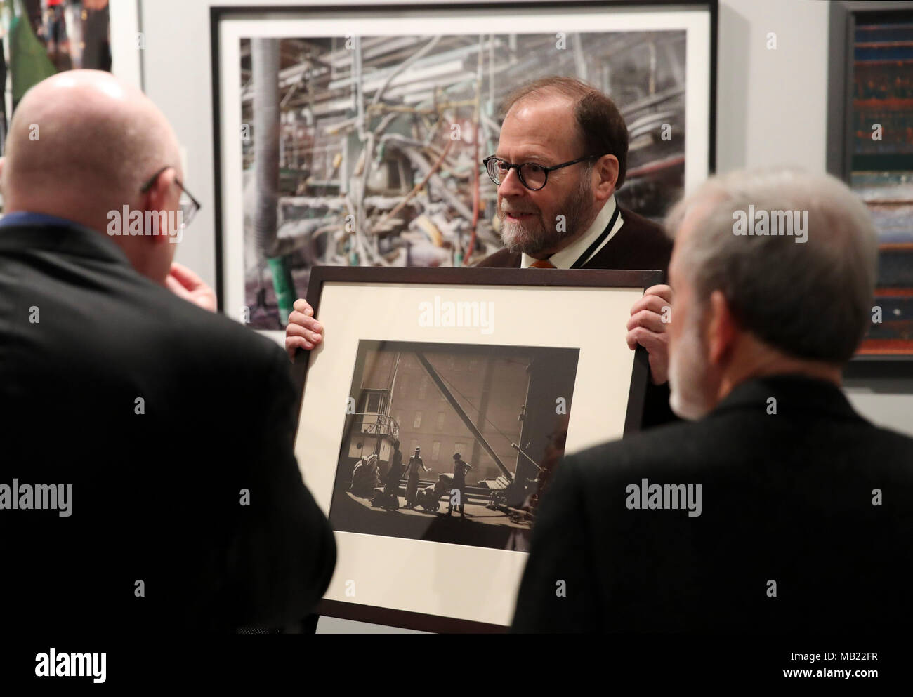 New York, USA. 5ème apr 2018. Un représentant de l'exposant (C) montre un morceau de photographies aux visiteurs à AIPAD (Association of International Photography Art Dealers)'s la photographie à New York, États-Unis, le 5 avril 2018. La 38e édition de la photographie se tiendra du 5 avril au 8 avril. Environ 100 des plus grands fine art photography galeries présentent une gamme de travaux, y compris de qualité musée contemporain, moderne, et des photographies du xixe siècle, ainsi qu'une photographie, d'art vidéo et nouveaux médias. Credit : Wang Ying/Xinhua/Alamy Live News Banque D'Images