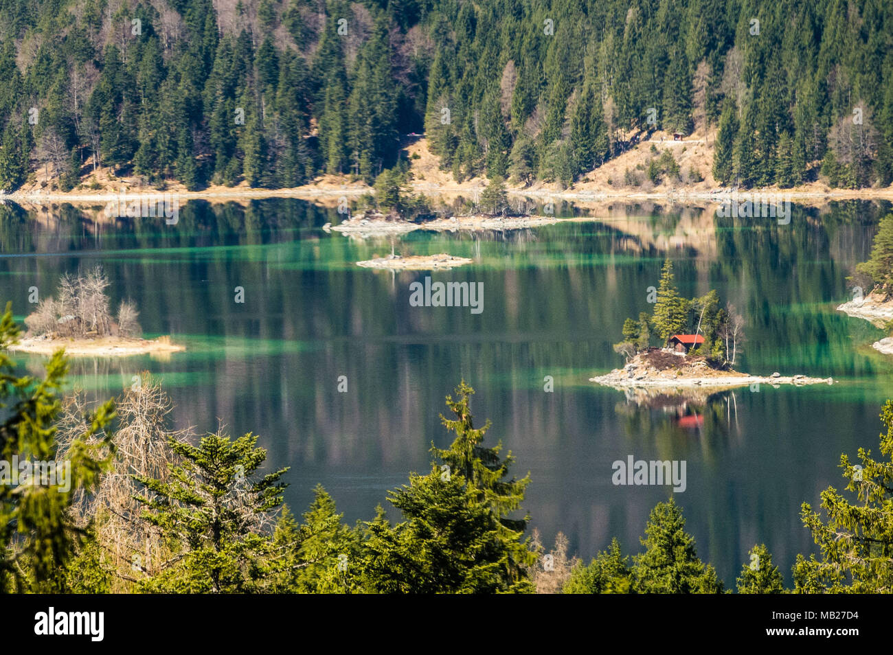 06 avril 2018, Allemagne, Berlin : un chalet au bord se reflète dans l'eau du lac Eibsee. Photo : Lino Mirgeler/dpa Banque D'Images