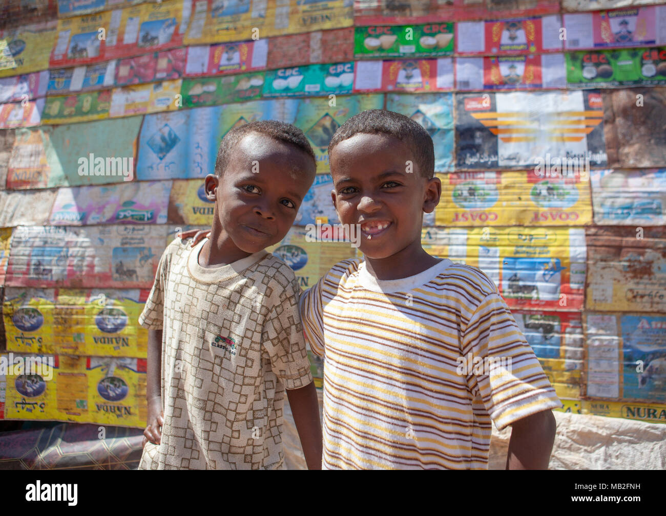 Deux garçons somaliens en face d'une maison faite de matériaux recyclés les bébés, province du nord-ouest, Berbera, Somalie Banque D'Images