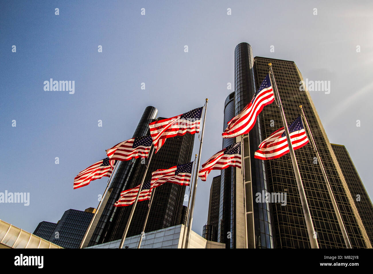 Je vois des drapeaux américains devant le Detroit Renaissance Center dans le quartier du centre-ville. Le gratte-ciel abrite le siège social mondial de General Motors. Banque D'Images