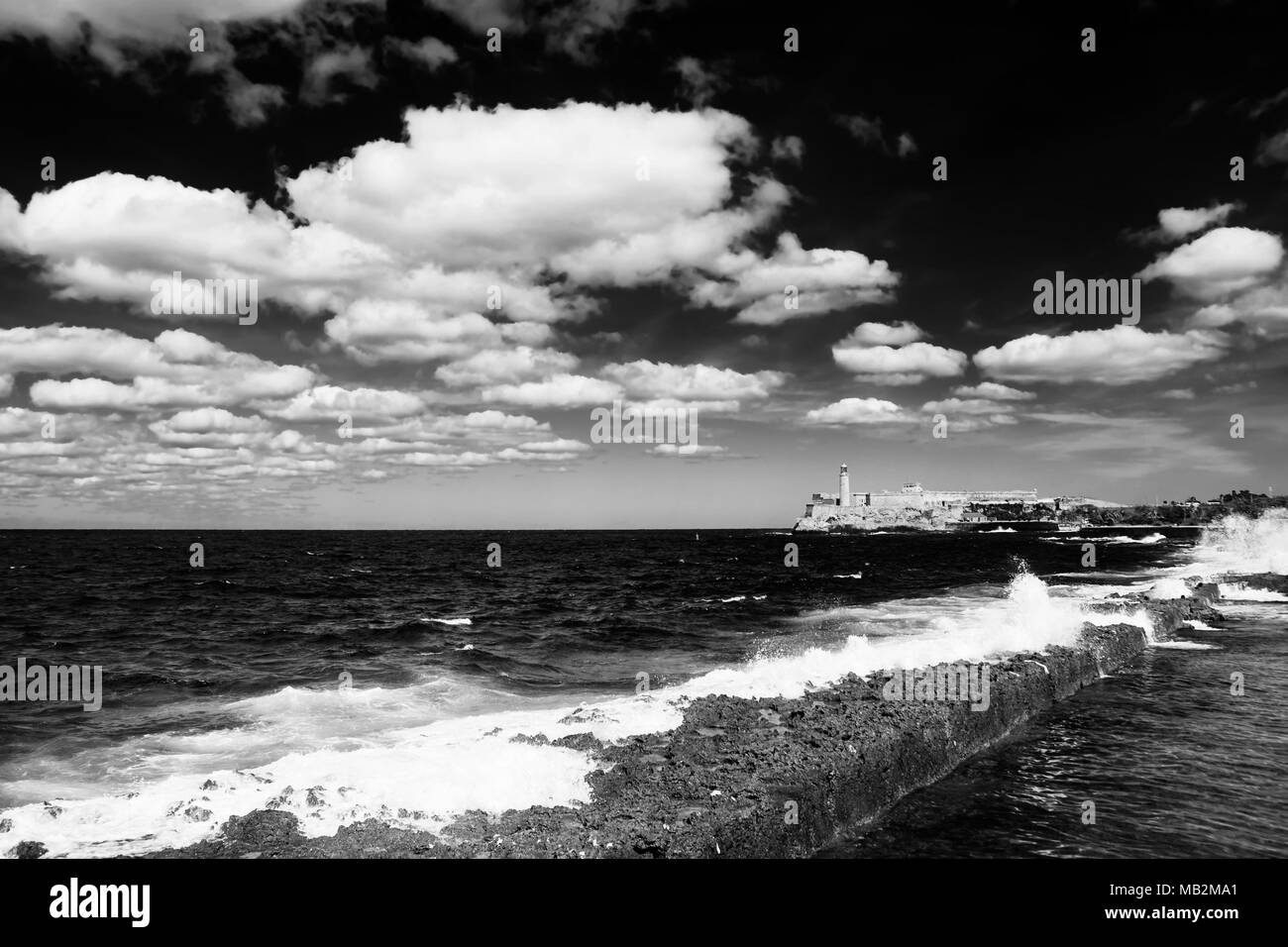 Promenade de la Malecon de La Havane, Morro Castle et son phare avec le fracas des vagues en noir et blanc Banque D'Images