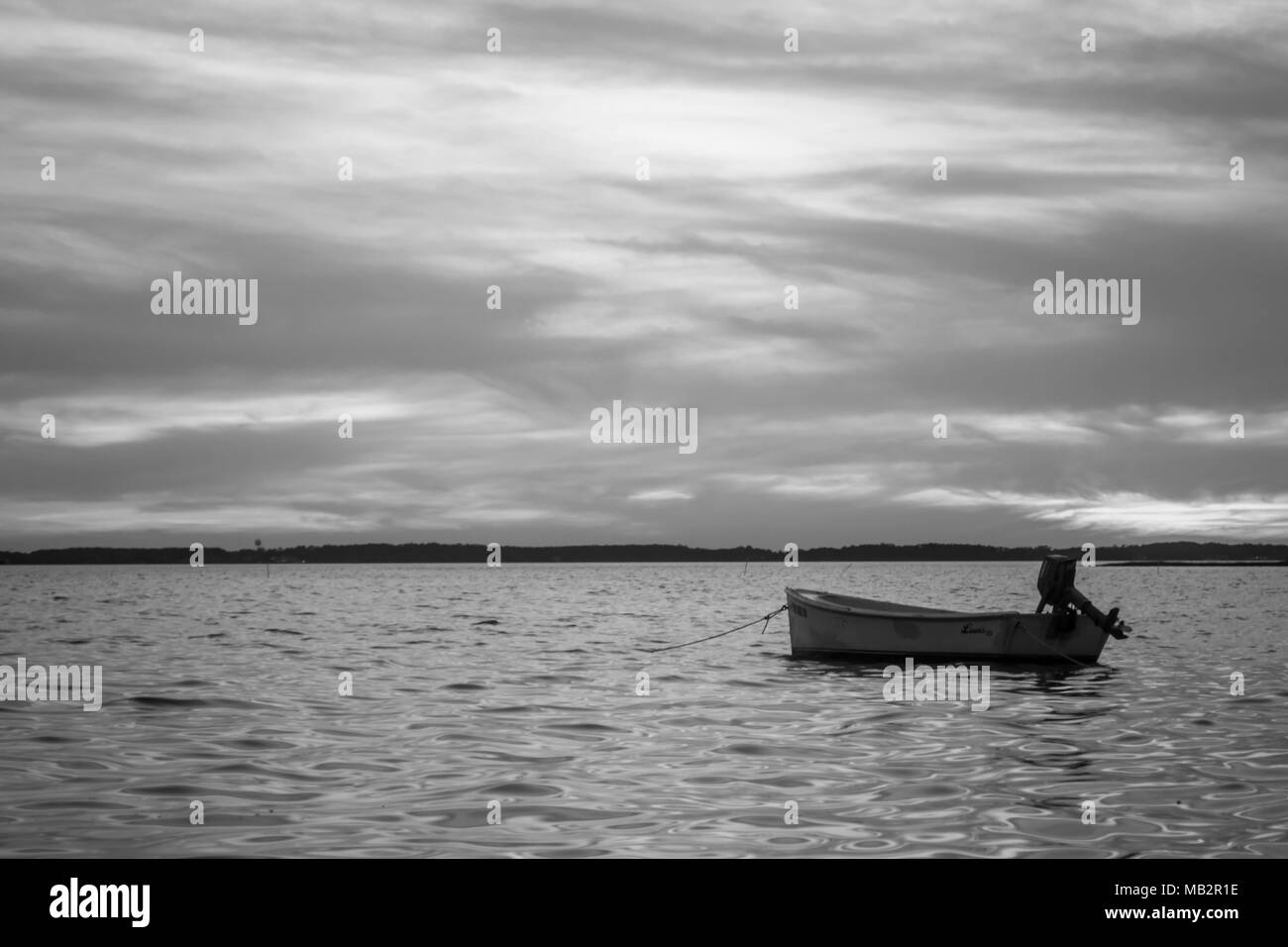 Seul bateau au coucher du soleil, inclinant doucement dans les eaux du son. Juste à l'extérieur de Harkers Island, Caroline du Nord. Le bateau attend le pêcheur Banque D'Images