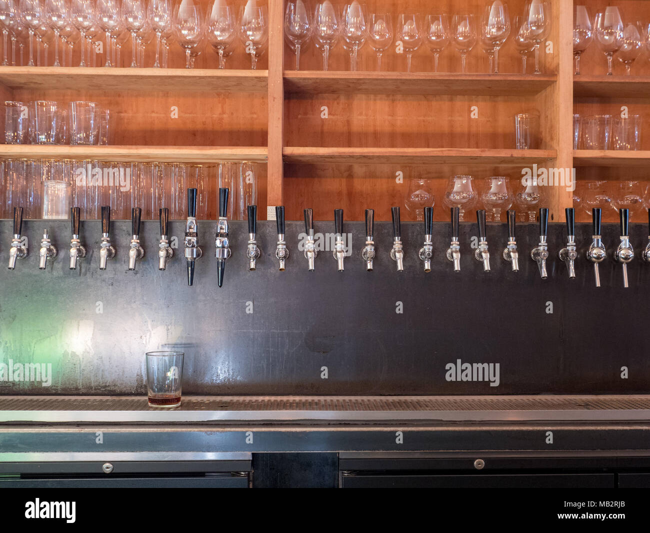Rangée de robinets en arrière de bar avec des verres sur l'étagère Photo  Stock - Alamy