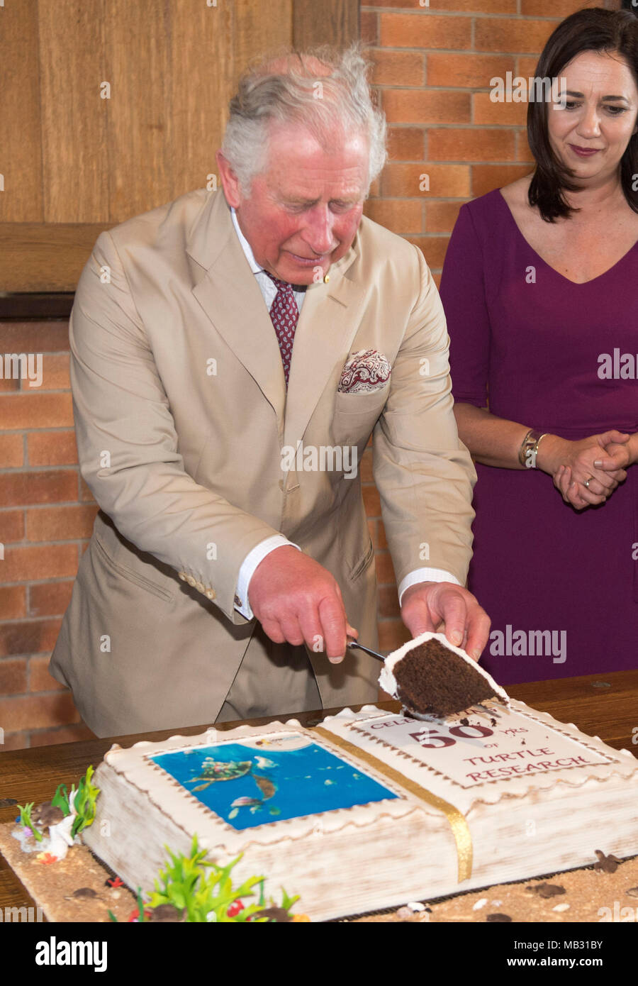 Le Prince de Galles coupe un gâteau pour marquer 50 ans de recherche sur les tortues au cours d'une visite de la distillerie de rhum de Bundaberg. Banque D'Images
