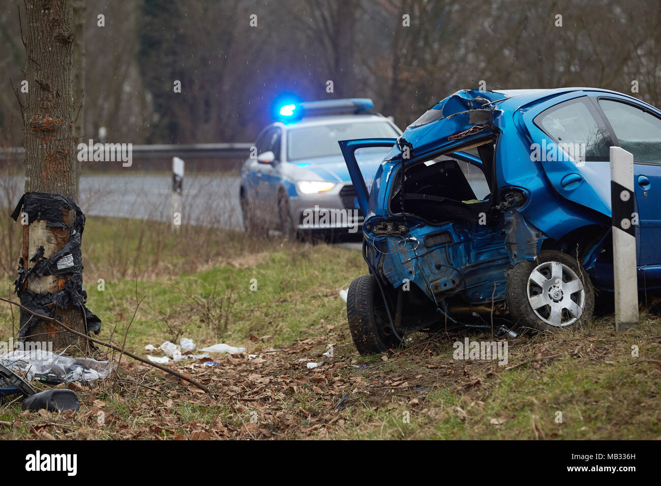 Accident de voiture sur une route de campagne, voiture avec peprallt arrière contre un arbre, voiture de police de clignoter à l'arrière, Allemagne Banque D'Images