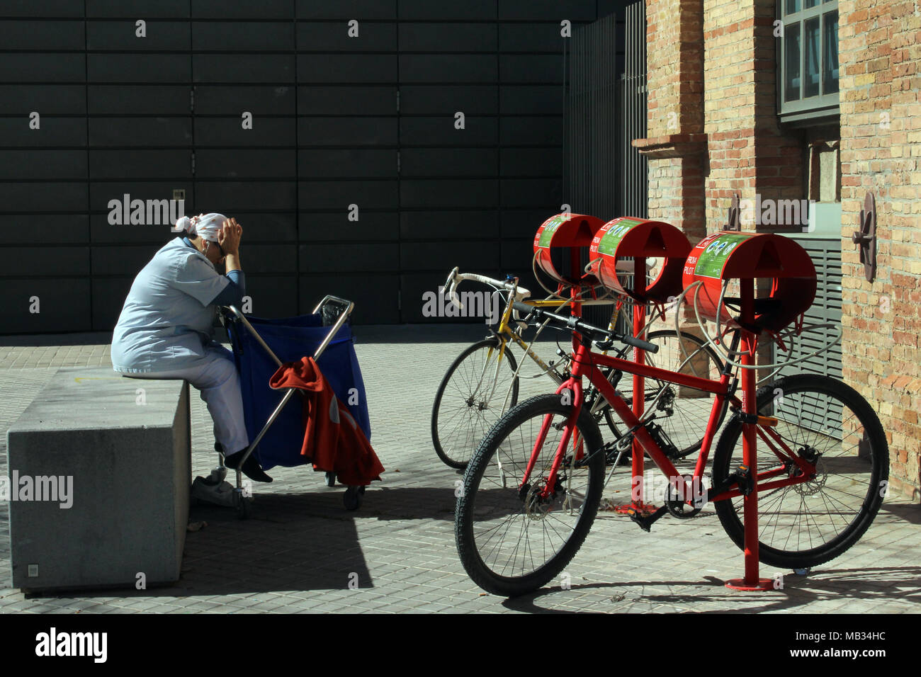 Femme de ménage assise devant les vélos, Poblenou, Barcelone, Espagne Banque D'Images