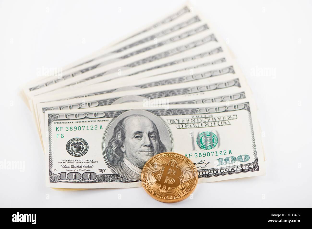 L'un bitcoin or par rapport à la pile de billets de cent dollars représentant le passé et le présent les tendances des finances. L'argent électronique virtuel numérique innovation voyage échange minier blockchain Banque D'Images