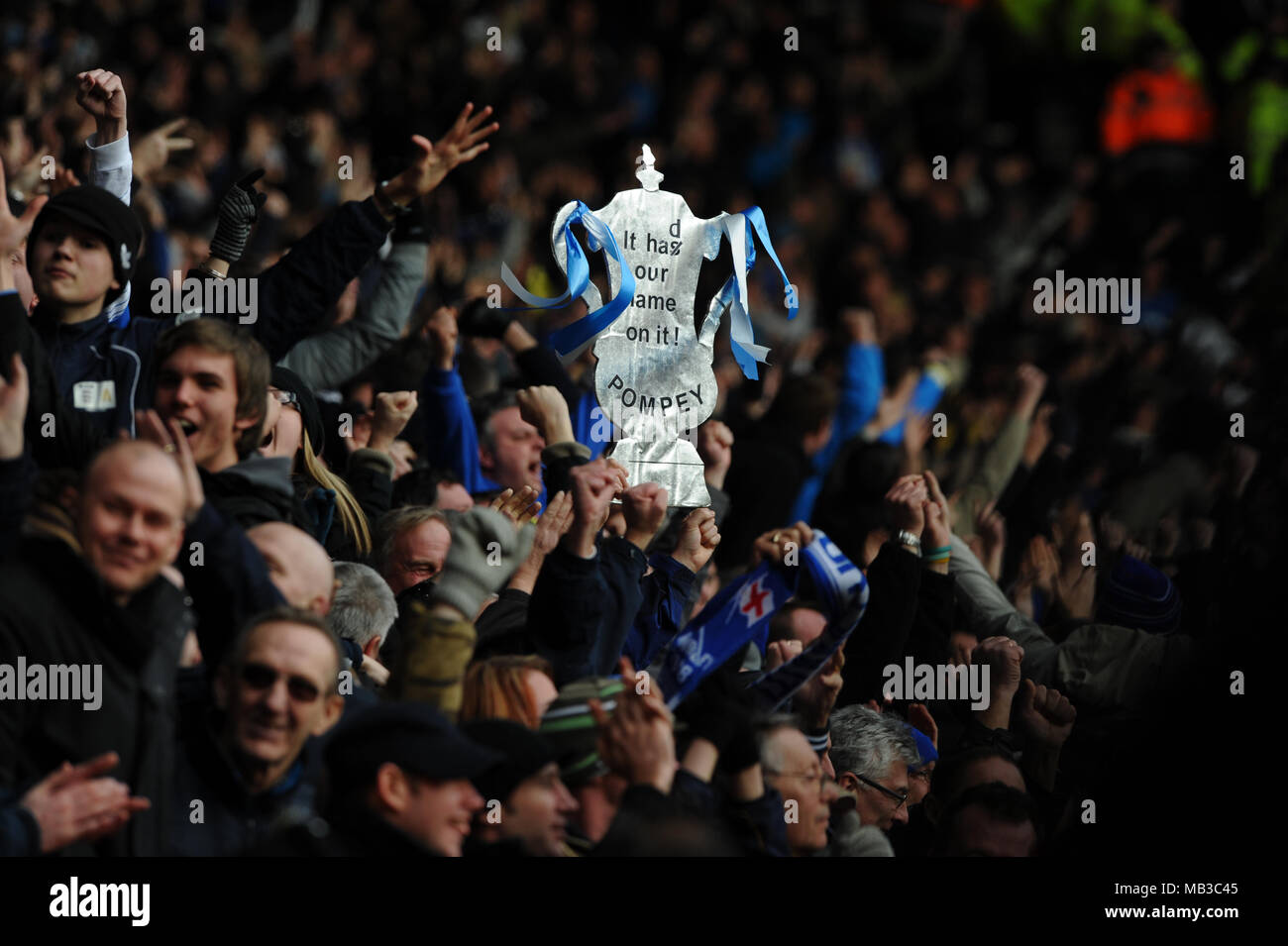 Portsmouth fans cheer et contenir jusqu'une réplique du trophée de la FA avec le slogan sur elle a notre nom. Banque D'Images