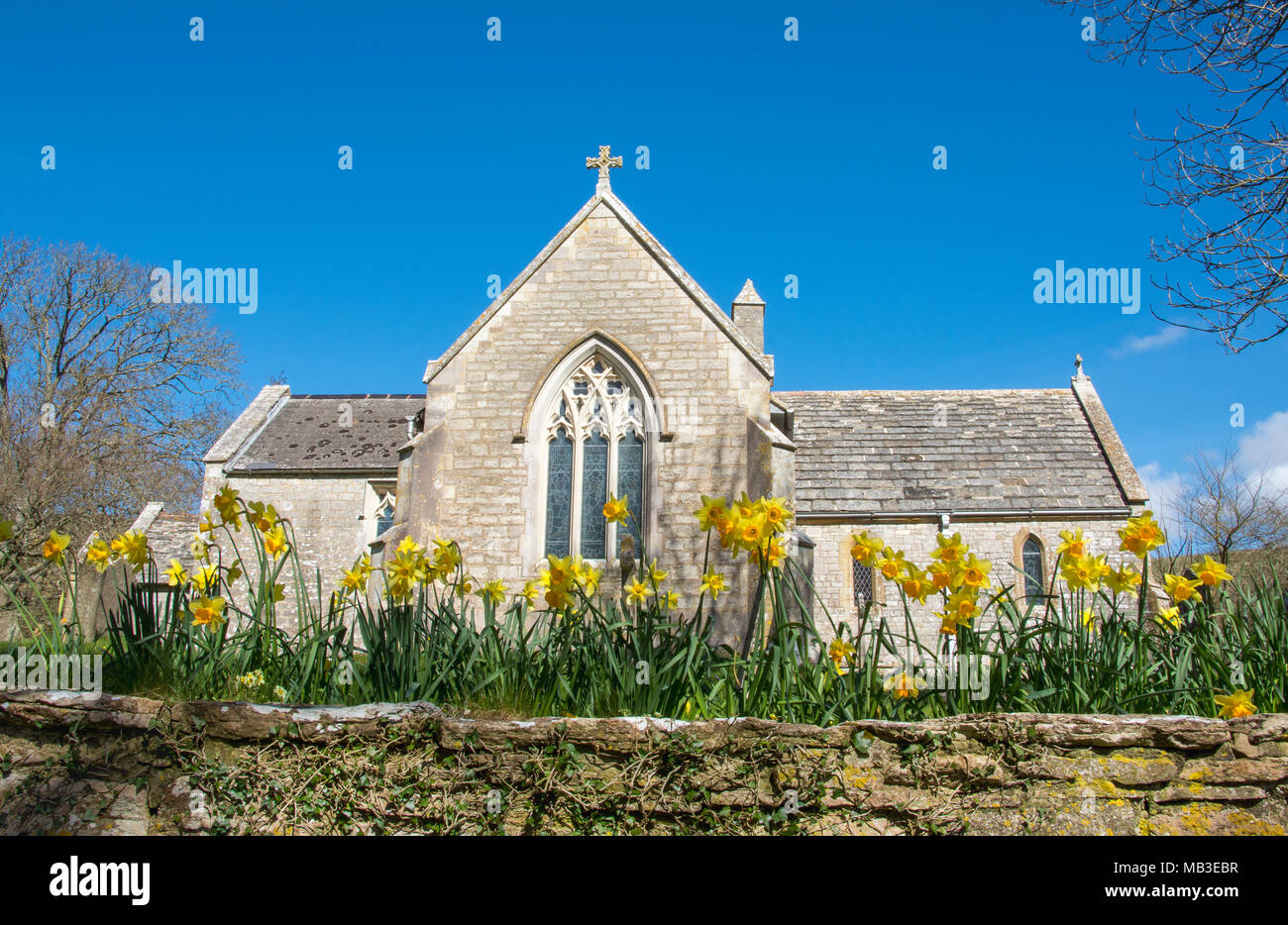 À l'église du village fantôme Tyneham, Dorset UK encadrée par les jonquilles Banque D'Images