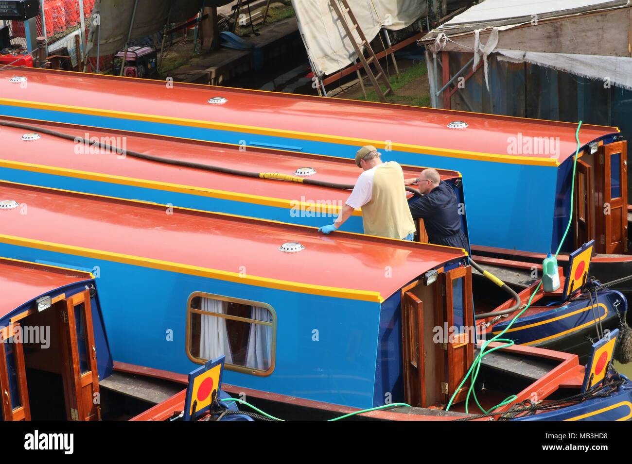 Les hommes qui travaillent sur une péniche / bateau à quai à quai Heyford, Oxfordshire, UK Banque D'Images