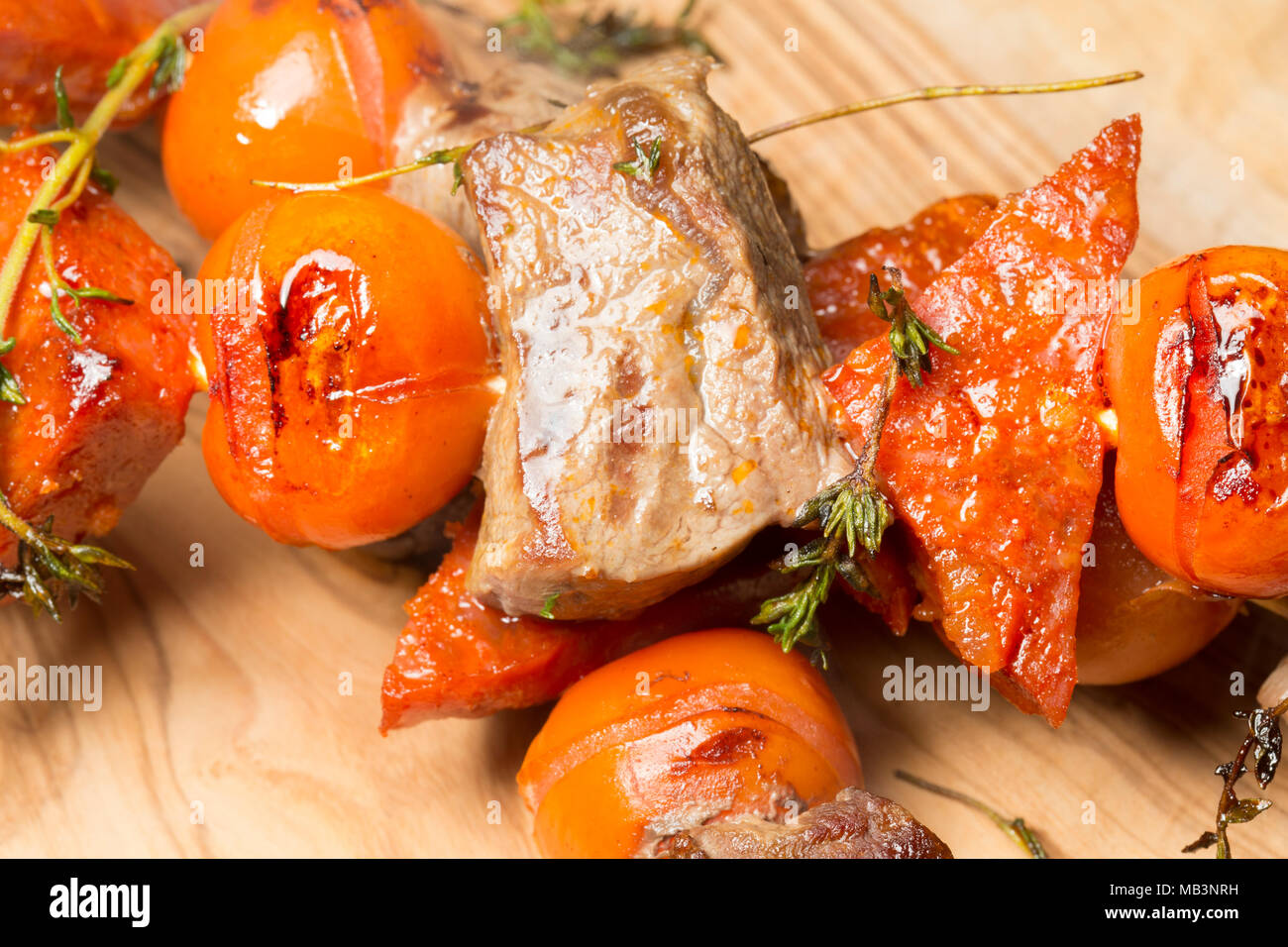 Sanglier, chorizo et tomates cerises et thym, cuite sur un grill George Foreman. La viande de sanglier est beaucoup plus sombre que le porc domestique et le goût Banque D'Images