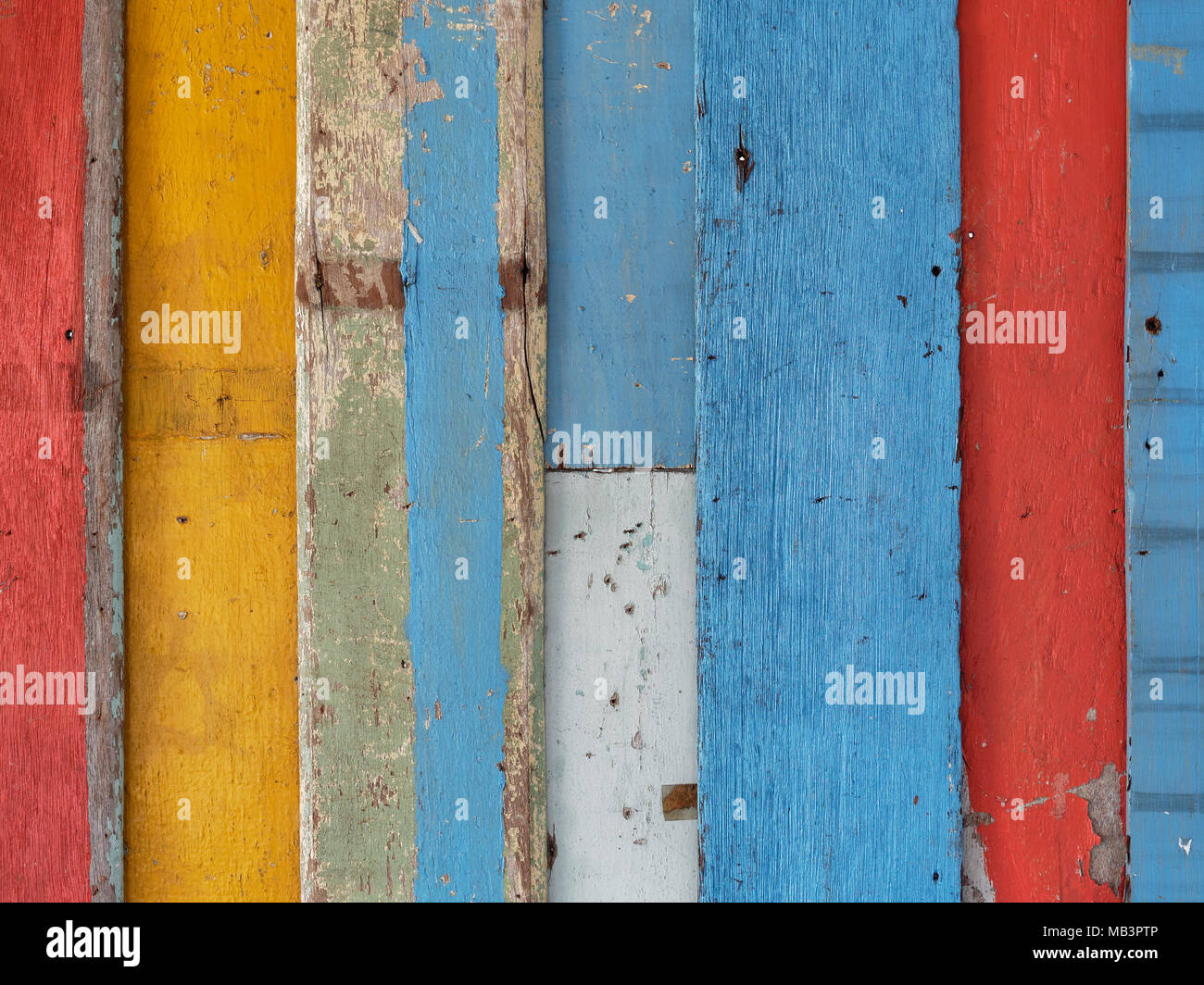 La surface du mur en bois étape colorées peintes en rouge, jaune, bleu, et marron en style rétro, vintage et utilisé comme arrière-plan Banque D'Images