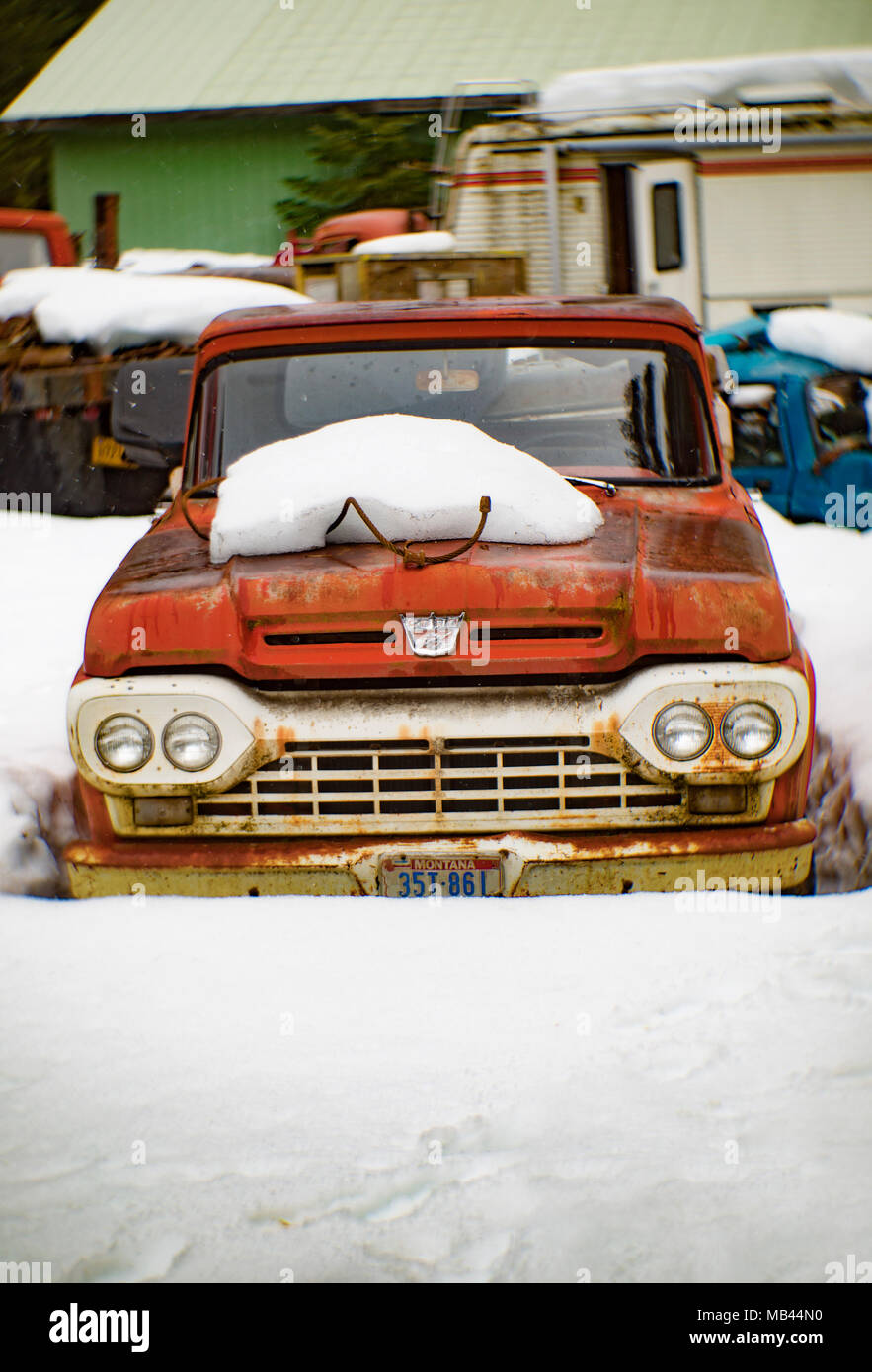 Un vieux, rouge 1960 Ford F-100 pick-up, dans la neige, sur le côté d'une grange, dans la région de Noxon, Montana. Cette image a été prise avec un ancien objectif Petzval et Banque D'Images