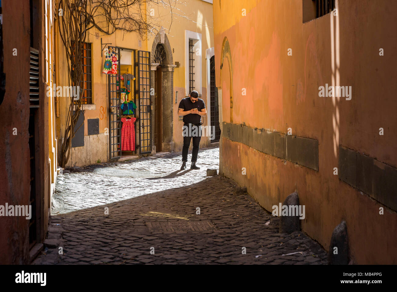 Contrôle de l'homme téléphone dans une rue latérale à Rome Banque D'Images