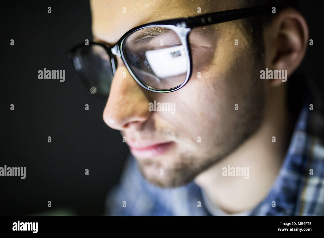 Libre de l'accent grave bel homme dans les verres à la recherche à l'écran. Banque D'Images