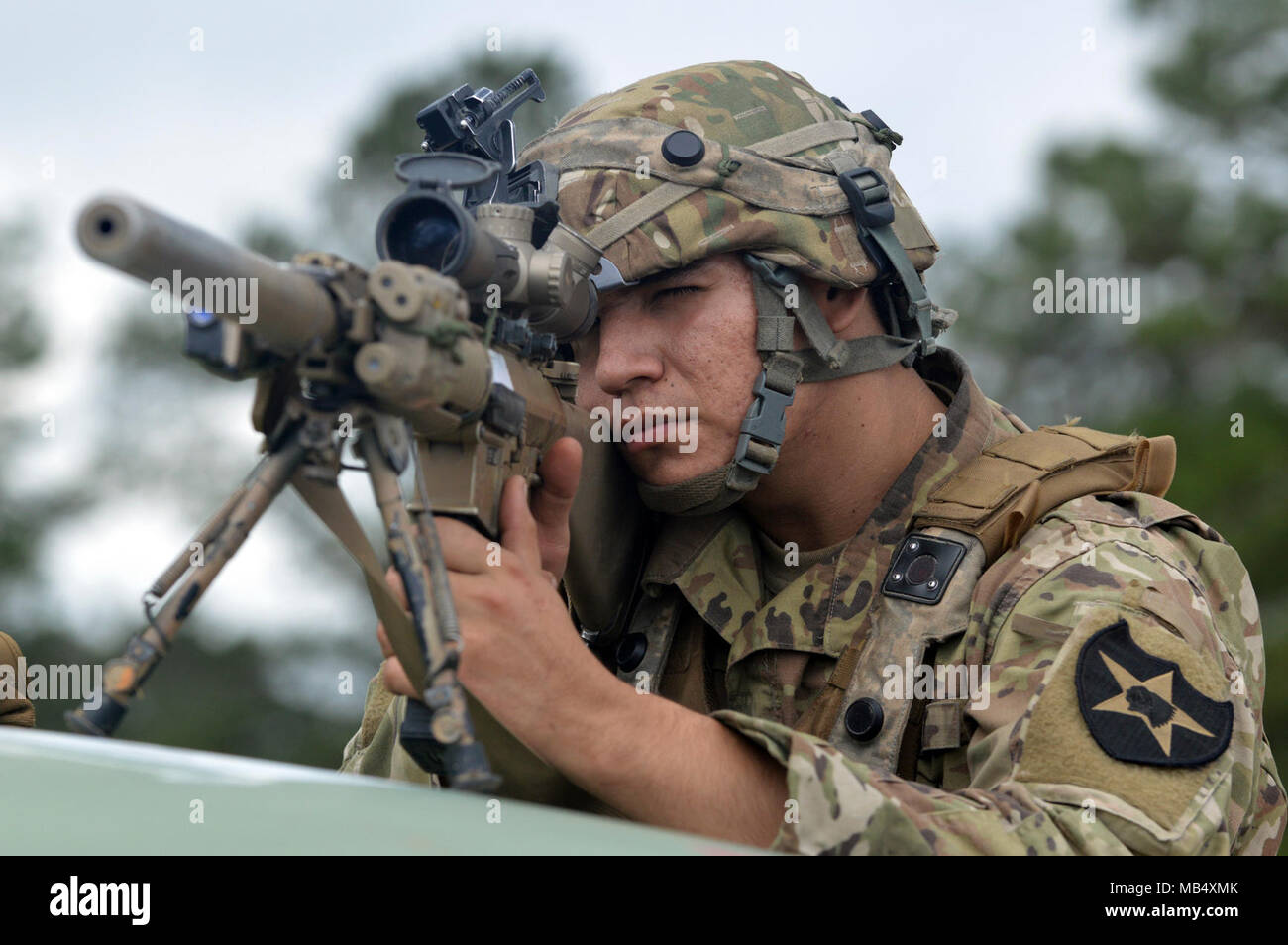 Un soldat affecté à la 2e Stryker Brigade Combat Team, 2e Division d'infanterie balaie l'horizon pour les forces opposées avec son fusil de sniper à Fort Polk, en Louisiane, le 20 février, 2108. Soldats avec 2e ID fournissent un appui à la 25e Division d'infanterie au cours de sa rotation au Joint Readiness Training Center. Banque D'Images