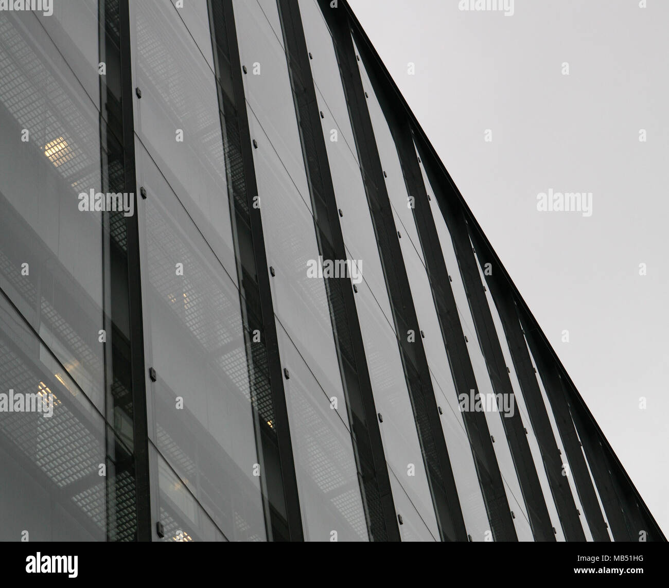 La façade de l'immeuble de verre et d'acier sur ciel couvert Banque D'Images