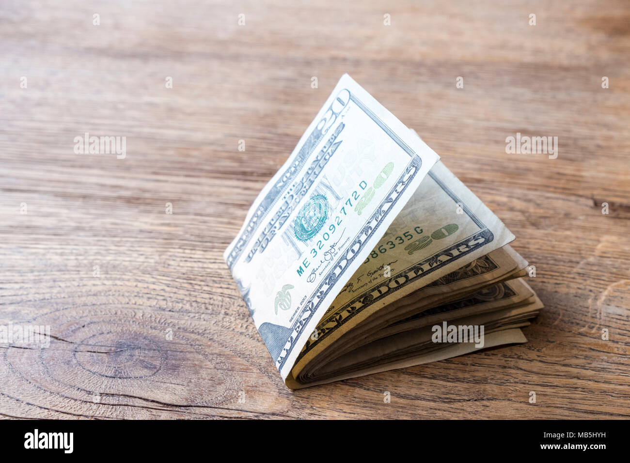 Argent pliée. Liasse de billets de dollars US sur une table Banque D'Images