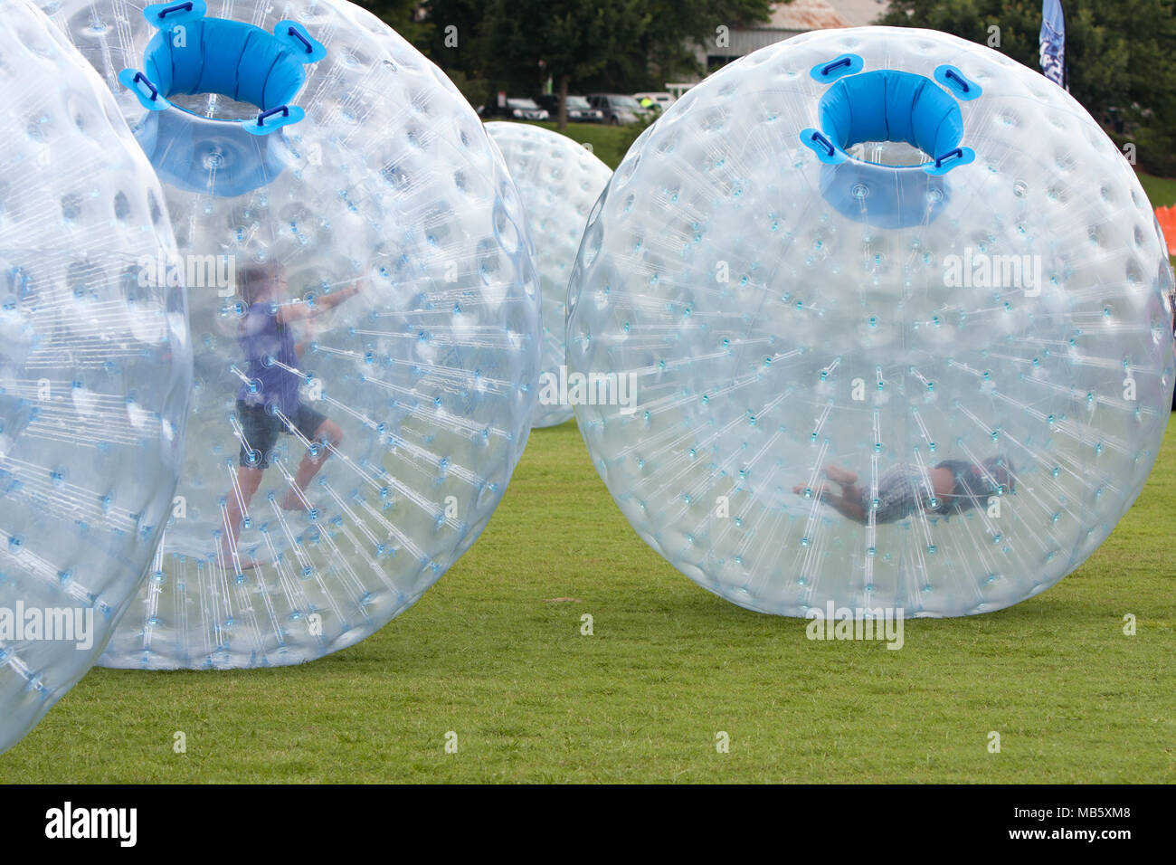 Les enfants se pousser autour des grandes zorbs sur une pelouse à l'Atlanta Ice Cream Festival à Piedmont Park, le 27 juillet 2013 à Atlanta, GA. Banque D'Images