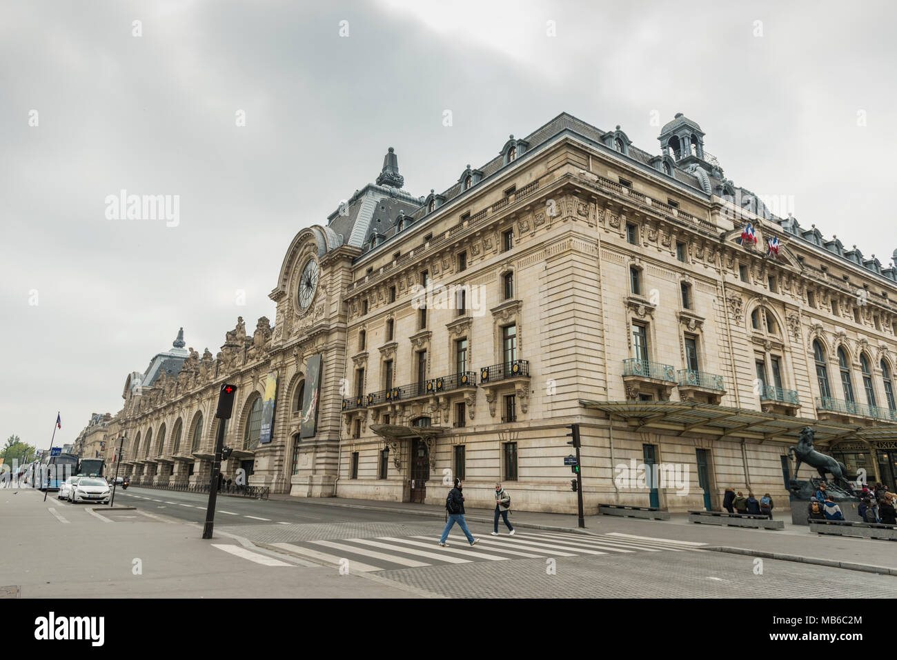 Deux personnes qui traversent de l'autre côté de la rue au Musée dOrsay sur les rives de la Seine à Paris, France Banque D'Images