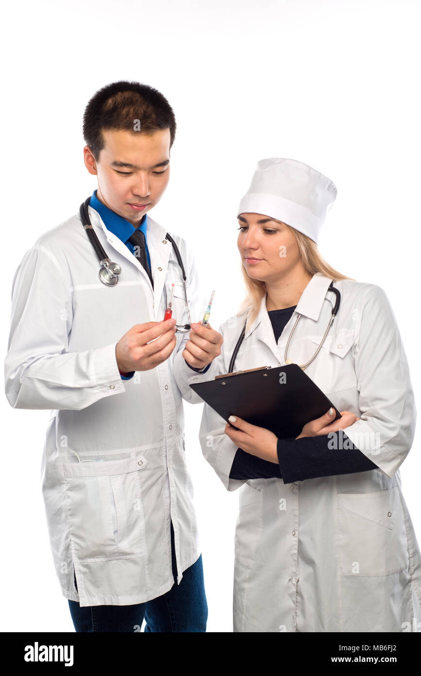 Un jeune médecin de l'apparence, de l'Asie montre une seringue d'un liquide rouge, une jeune fille médecin Banque D'Images