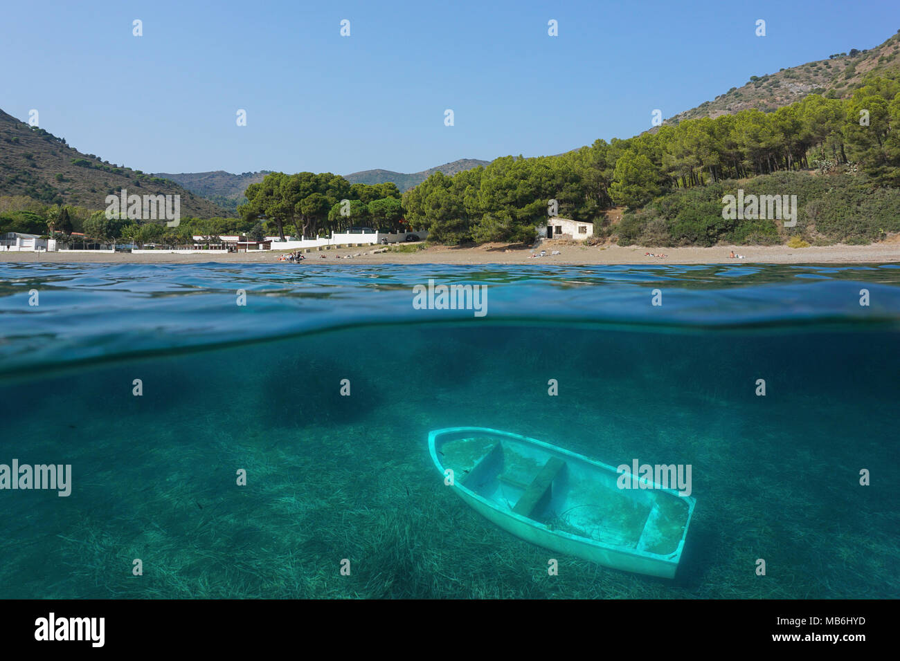 Littoral Espagne Cala Montjoi plage sur la Costa Brava et un petit bateau épave sous l'eau, vue fractionnée au-dessus et au-dessous de la surface de l'eau, mer Méditerranée Banque D'Images