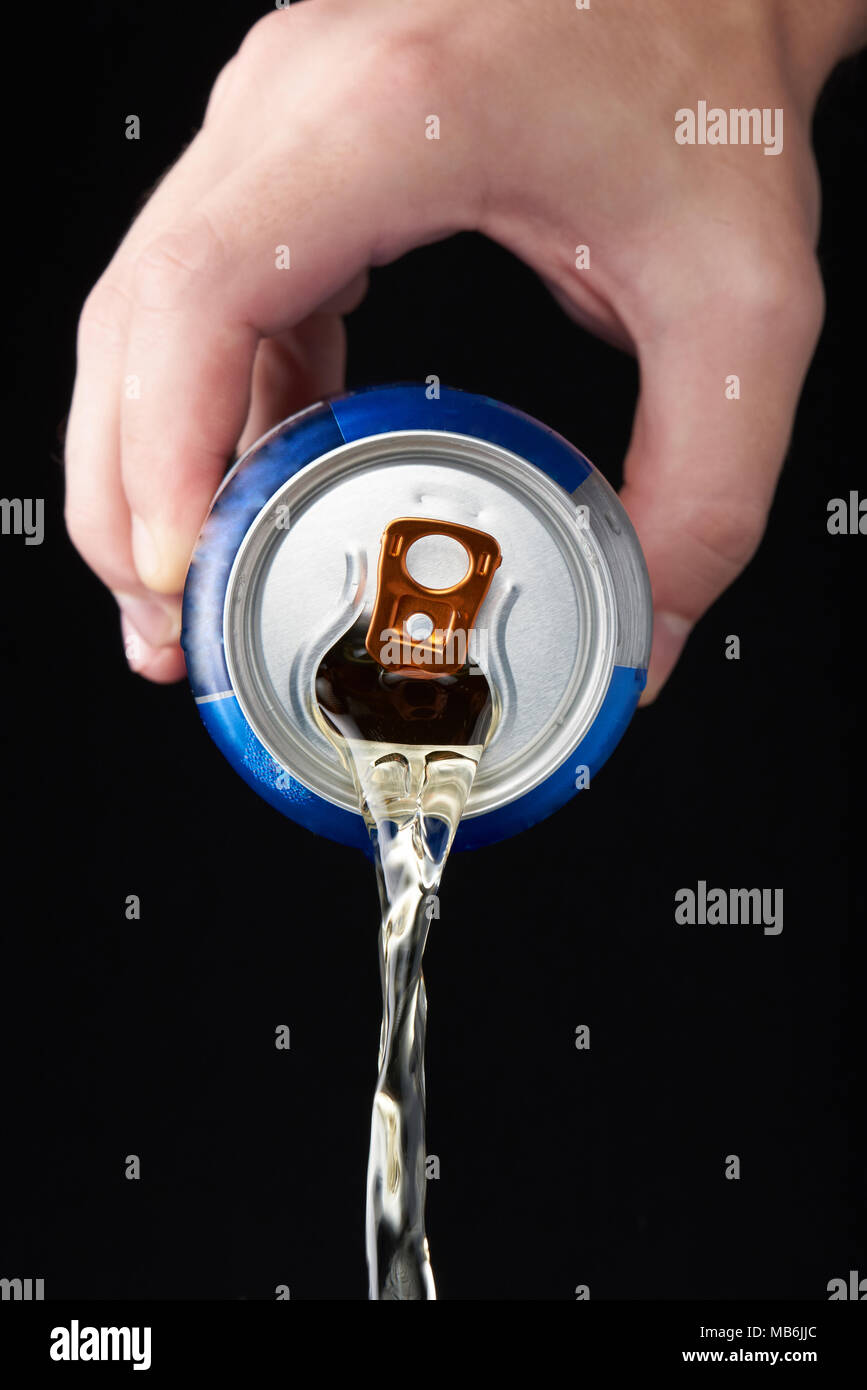 Servir la bière à la main à partir de métal isolé sur fond noir Banque D'Images