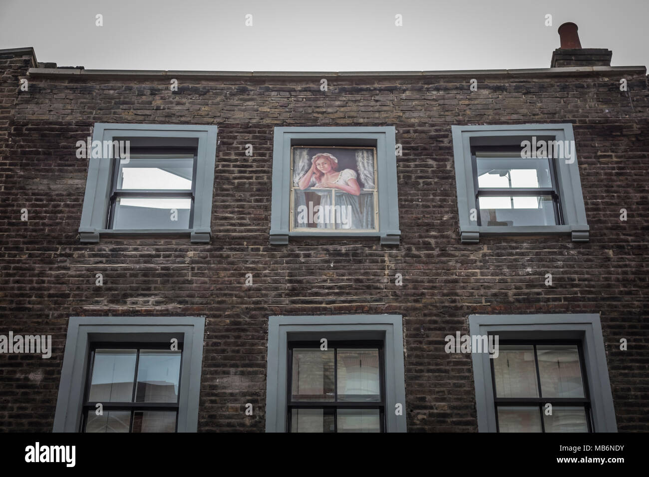 Une femme à l'étage dans la fenêtre, au-dessus de la maison publique Newman Arms sur Rathbone Street, Fitzrovia, Londres, Angleterre, Royaume-Uni Banque D'Images