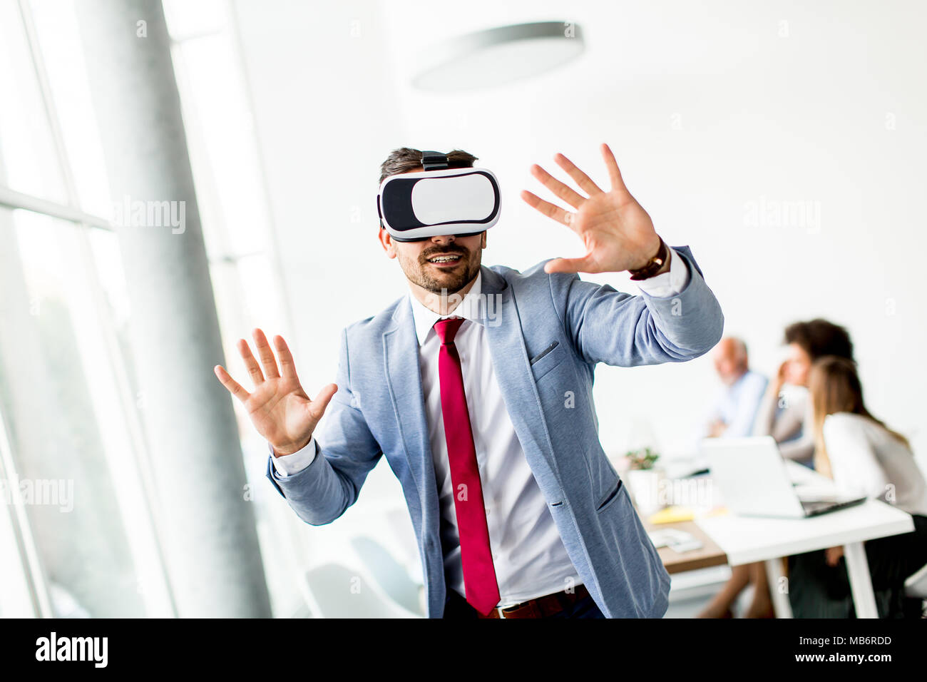 Homme d'affaires moderne avec casque de réalité virtuelle dans le bureau s'amusant Banque D'Images
