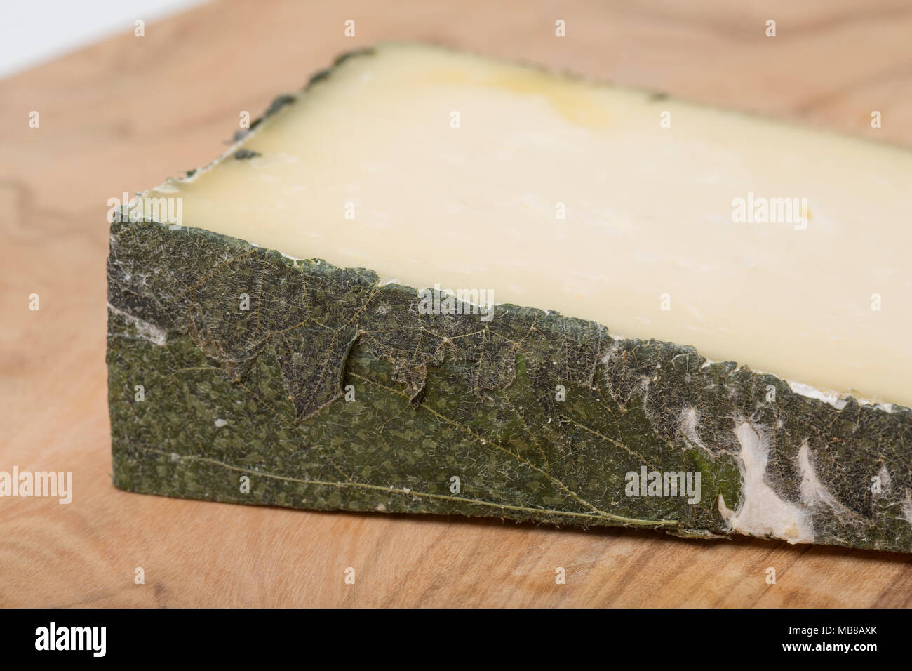 Cornish Yarg est un fromage au lait de vache et est enveloppée d'orties avant son échéance. On voit ici sur une planche à découper en bois d'olivier avec l'emballage d'ortie. U Banque D'Images