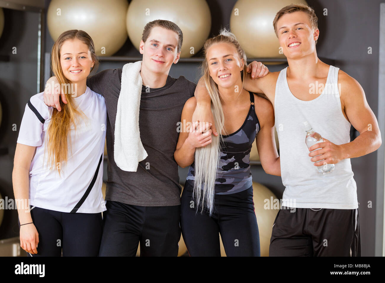 Entraînement des hommes et des femmes debout amis ensemble dans une salle de sport Banque D'Images