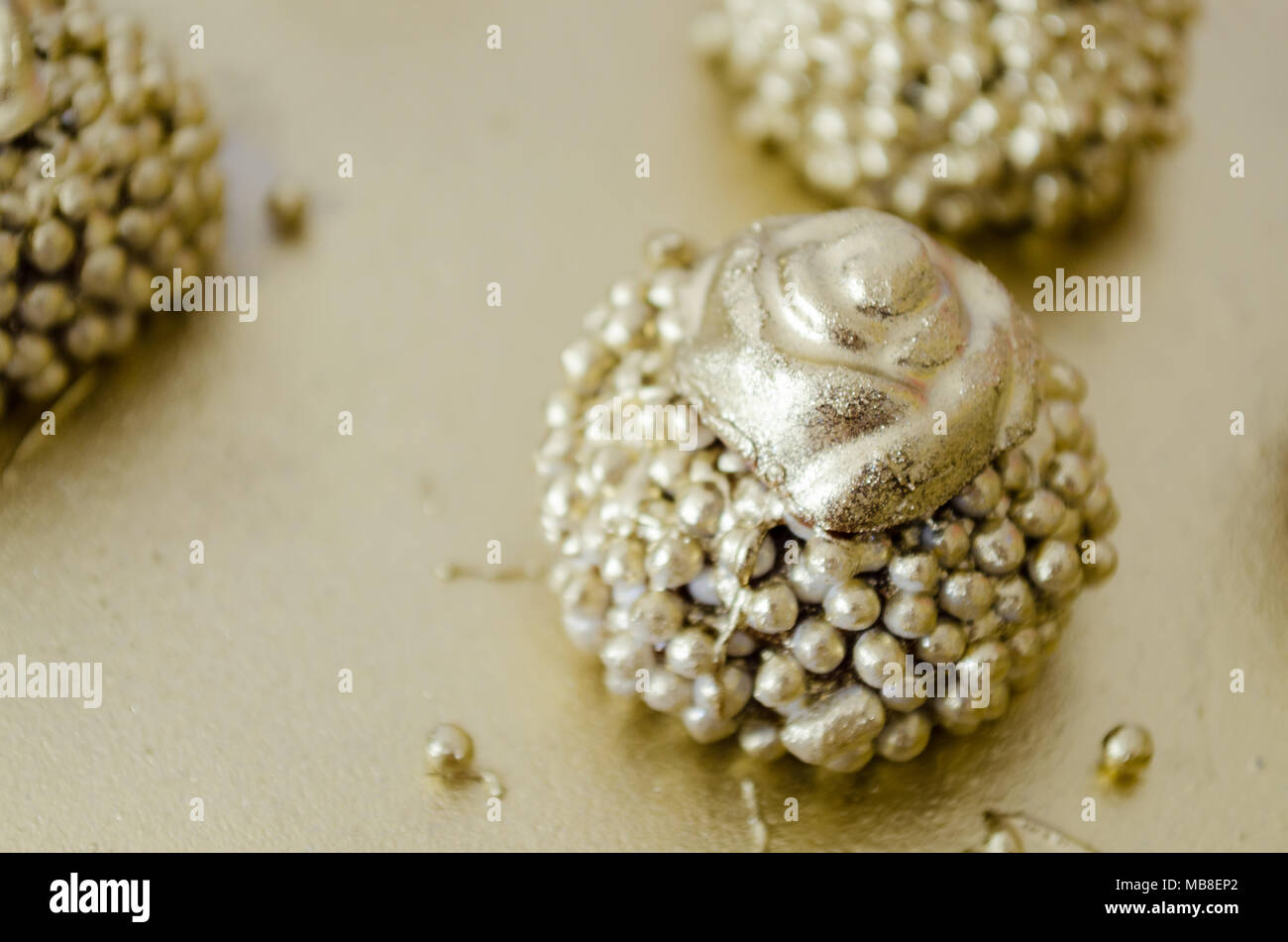 Chocolat granulé le brigadier avec boules croquantes surmontée de peinture or et une fleur de chocolat sur le dessus. Sur un plateau d'or Vue d'en haut. Copier l'espace. Banque D'Images