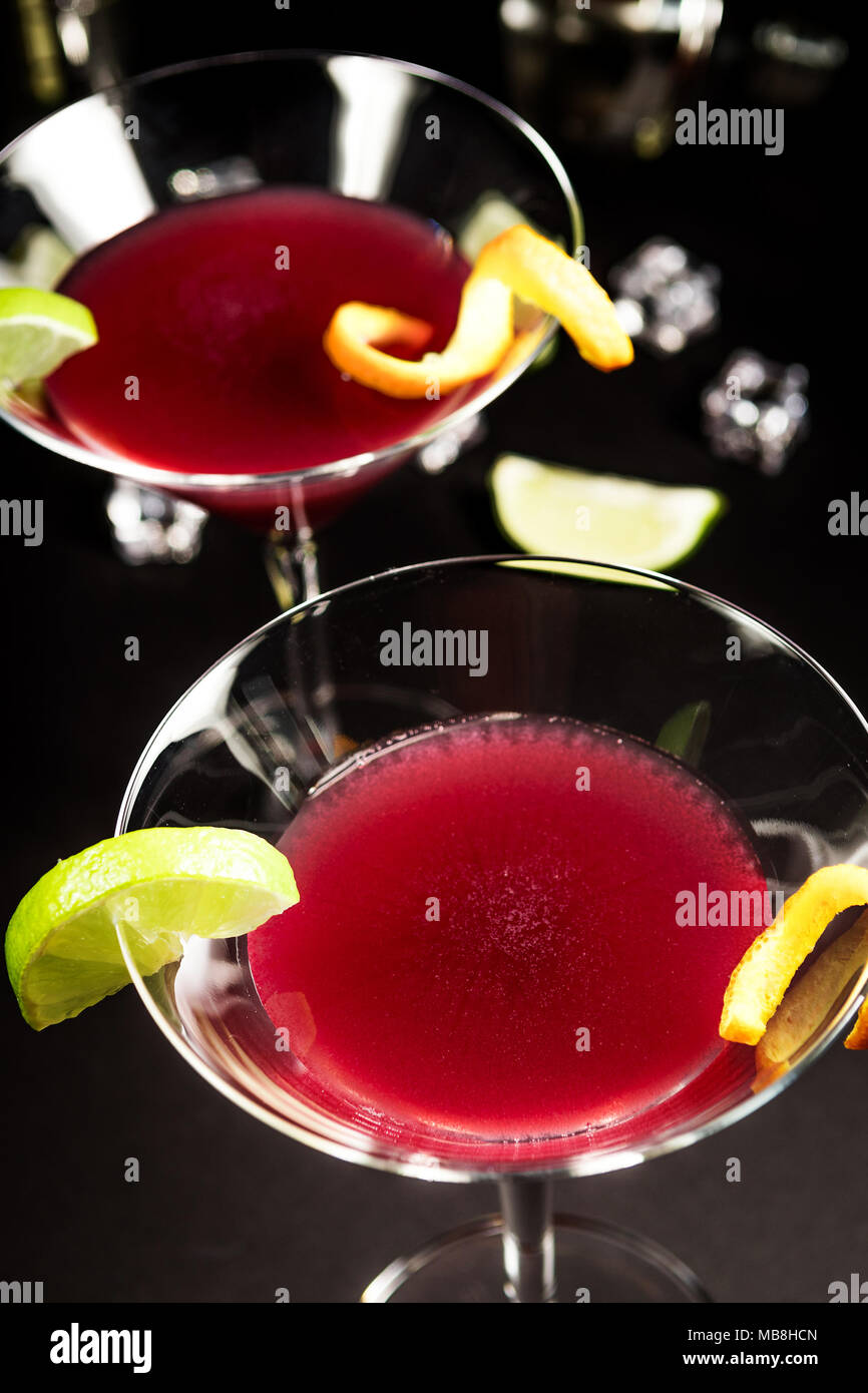 Boire de l'alcool cocktail Cosmopolitan avec de la chaux sur fond noir Banque D'Images