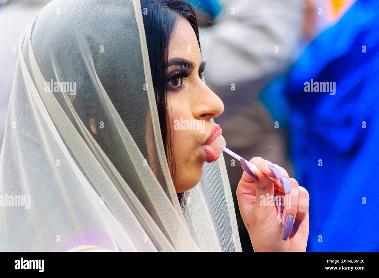 Le portrait dune femme sikh portant un voile avec de longs ongles sucer  une sucette au Festival Sikh de Vaisakhi à Glasgow, Écosse, Royaume-Uni  Photo Stock - Alamy