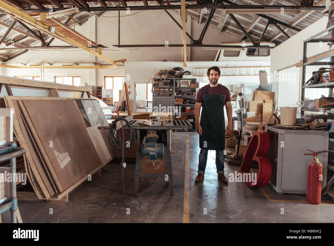 Travailleur du jeune par un banc permanent vu dans son atelier Banque D'Images