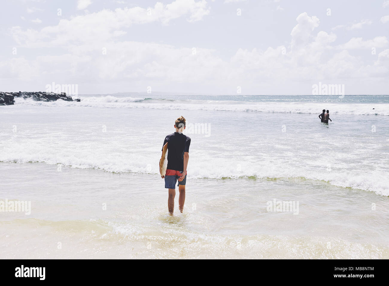 Jeune homme de race blanche sur une plage de sable doré à Noosa dans le Queensland, Australie Banque D'Images