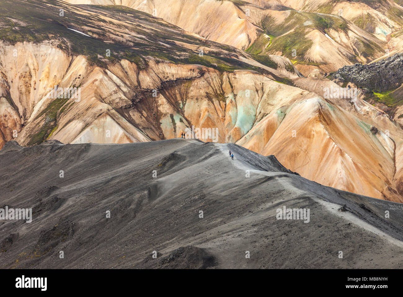 Les randonneurs de la montagne Blahnukur Ordre décroissant avec les pentes du volcan Brennisteinsalda derrière Landmannalaugar Islande Banque D'Images