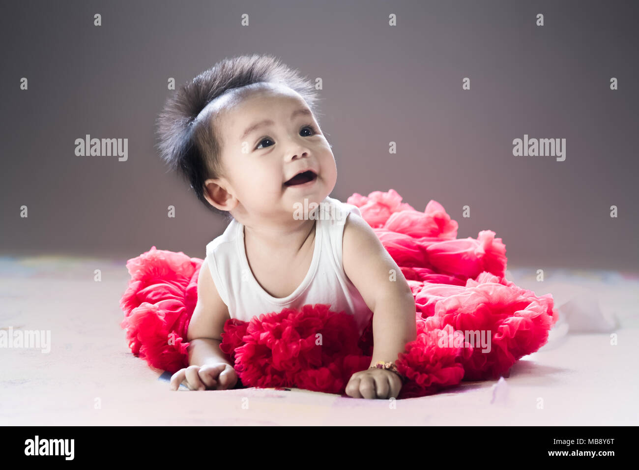 Asian new born baby sit et sourire sur un lit dans la chambre. Banque D'Images
