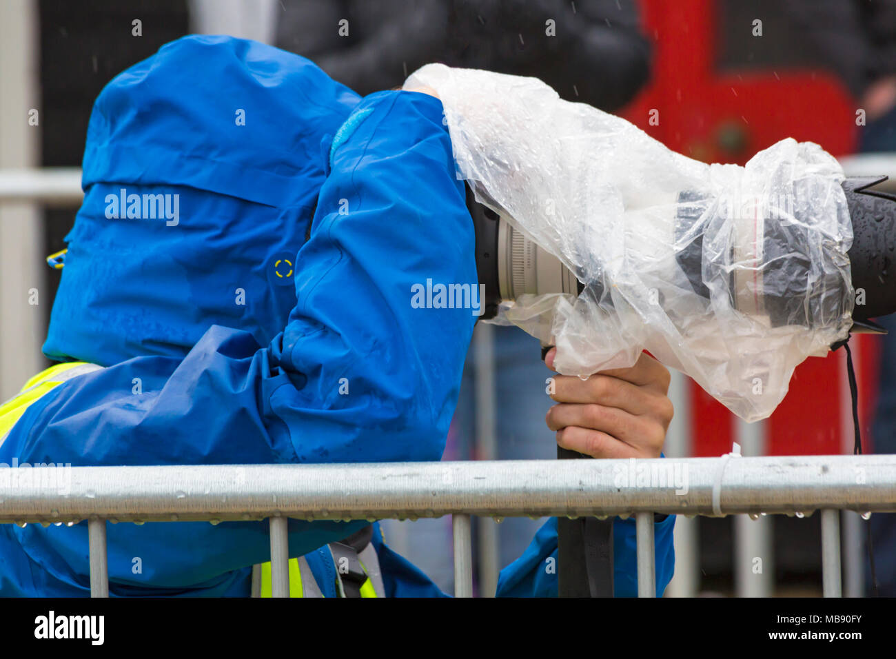 Photographe essayant de garder lui-même et son équipement à jour de pluie humide à sec Banque D'Images