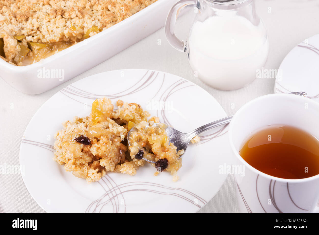 Plateau servi avec la traditionnelle ou apple crumble rhubarbe. Une portion dans une assiette et émietter dans un plat allant au four Banque D'Images