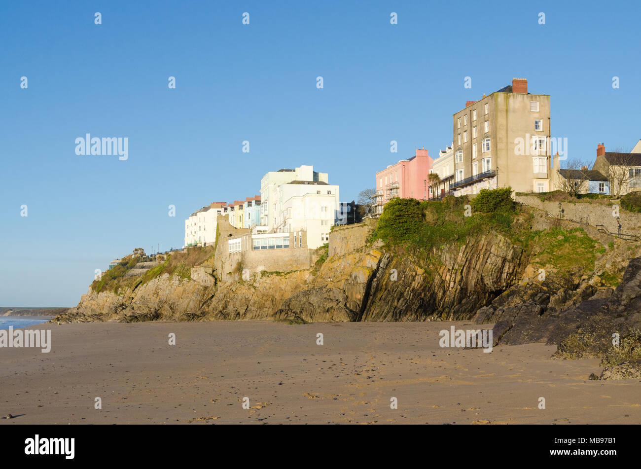 Maisons colorées donnant sur la plage de Tenby, château dans le soleil du matin Banque D'Images