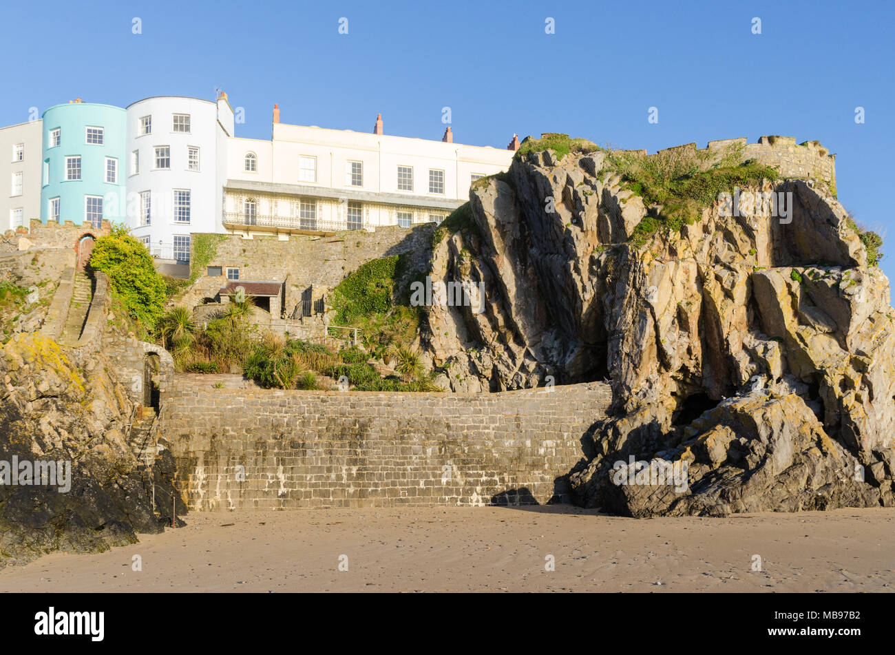 Maisons colorées donnant sur la plage de Tenby, château dans le soleil du matin Banque D'Images