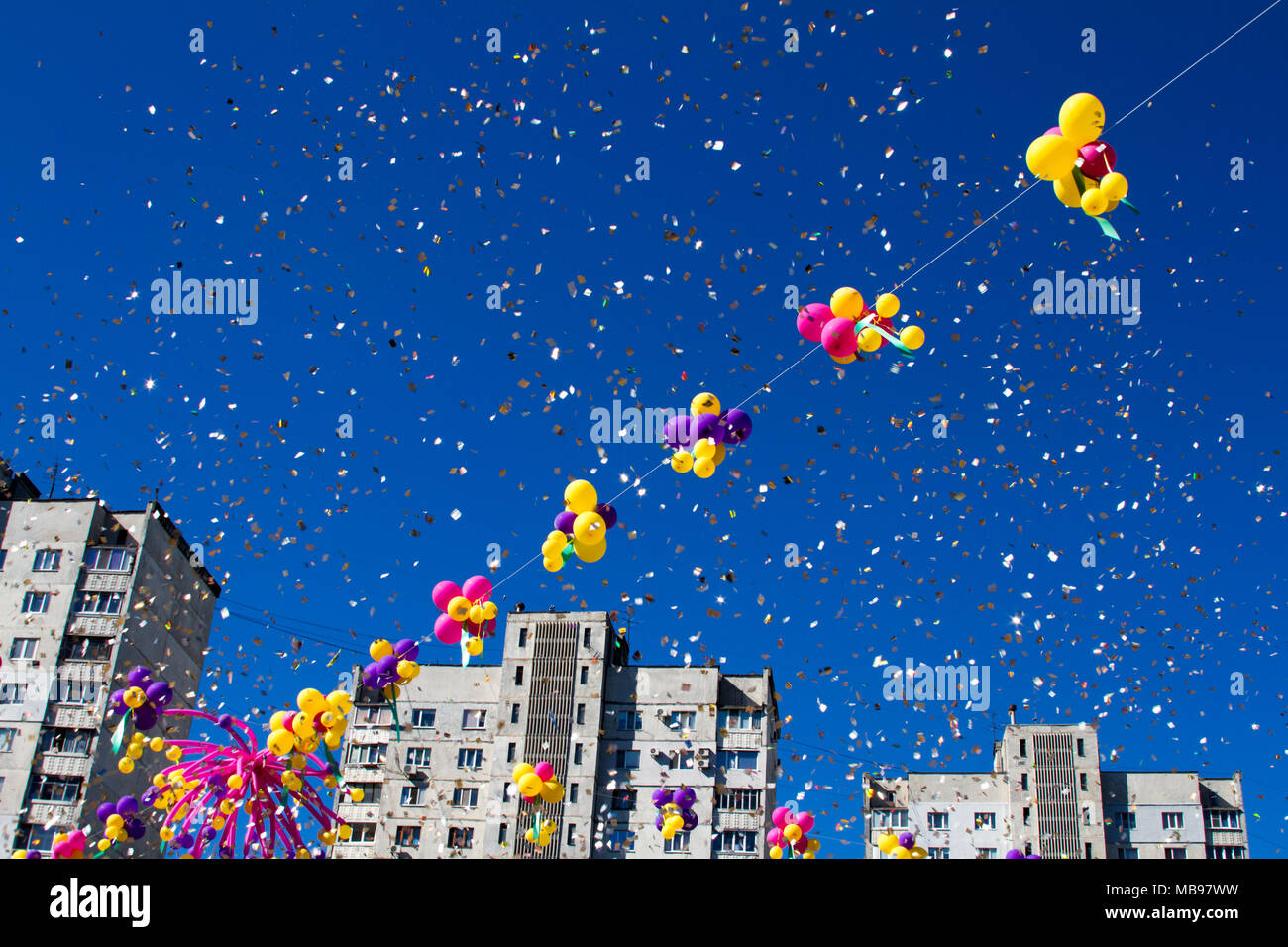 Colorful ballons gonflables multicolores voler dans l'air à l'arrière-plan d'arbres et de ciel bleu pendant le festival de fête. Saluer en ciel de balloo colorés Banque D'Images