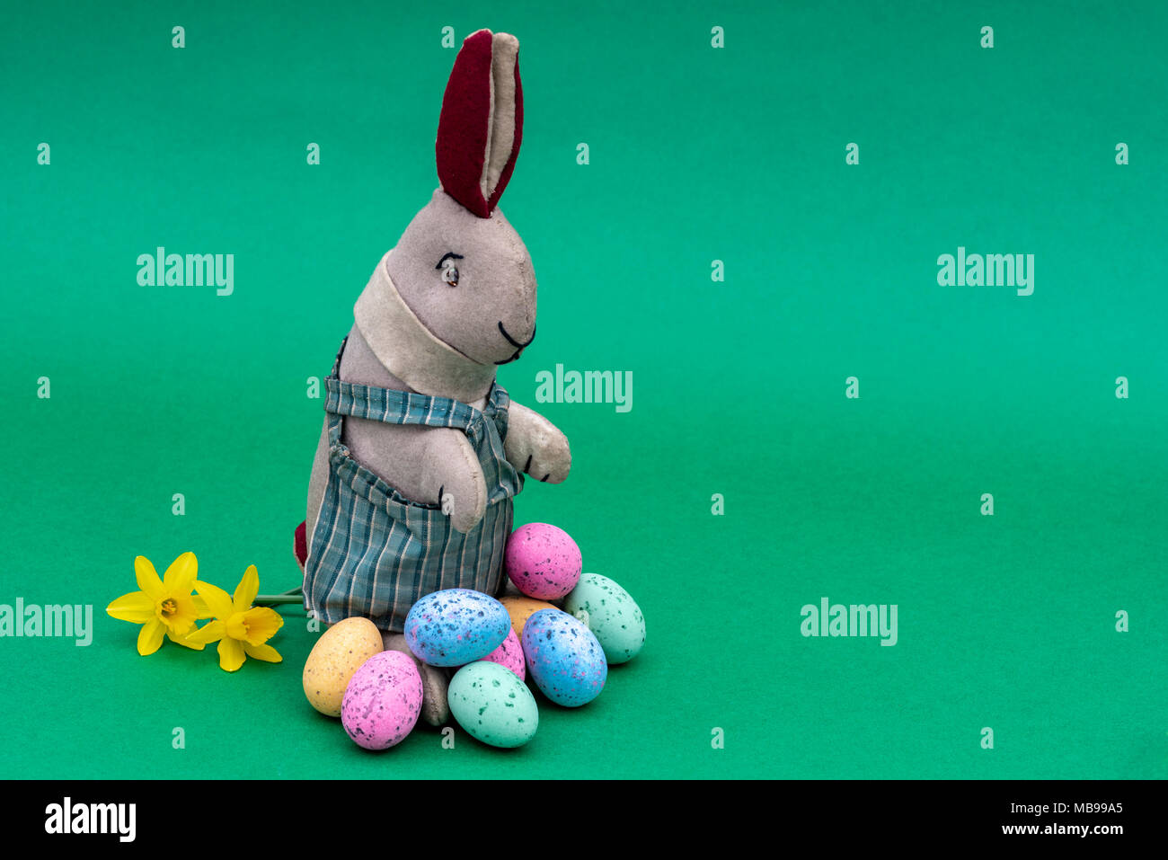 Vintage toy lapin, bunny, avec une pile d'oeufs de Pâques au chocolat. Banque D'Images