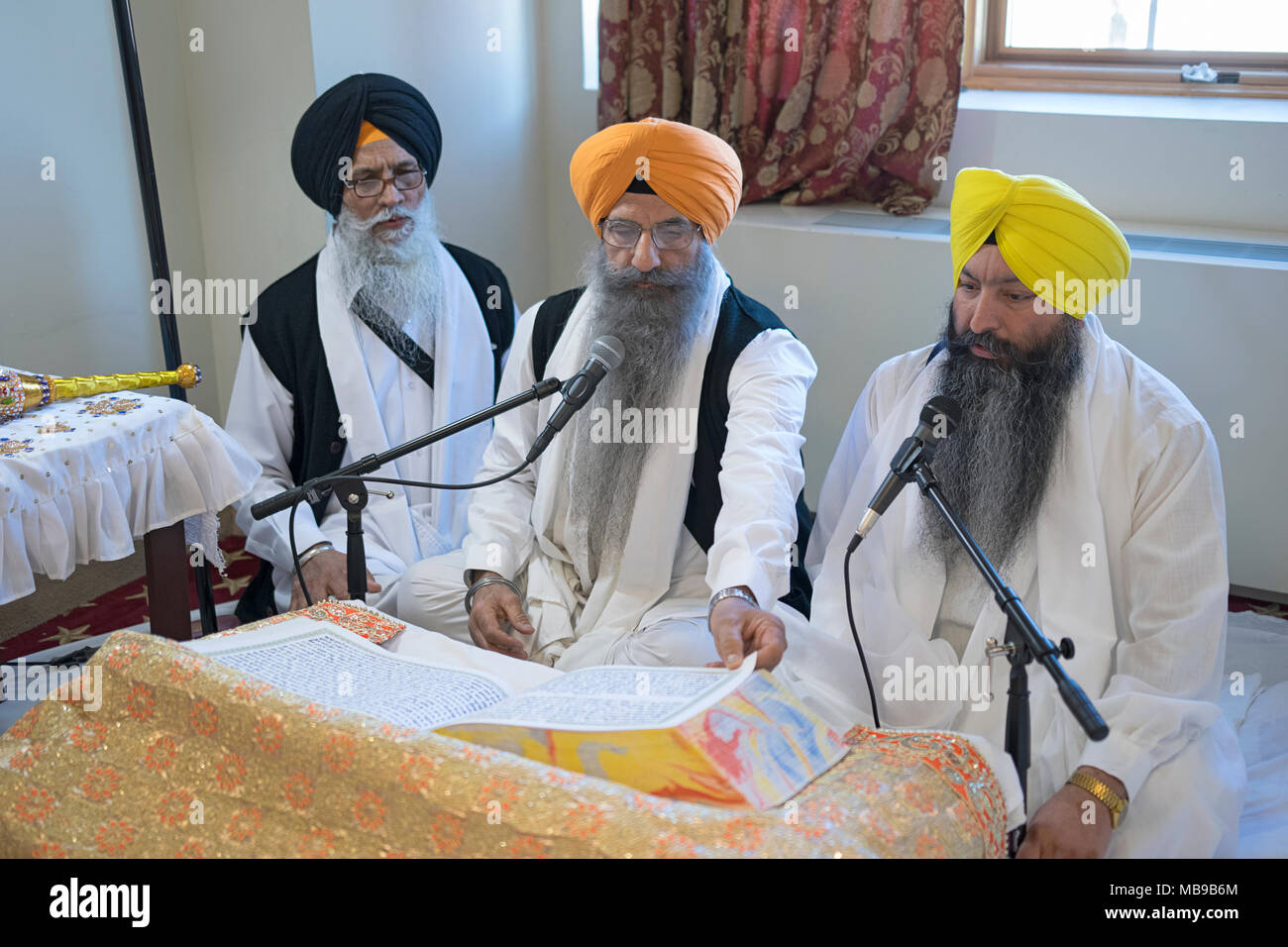 Prêtre sikh, Granthis, lecture Sri Guru Granth Sahib, qui est le livre saint du sikhisme. À Richmond Hill Queens, New York. Banque D'Images