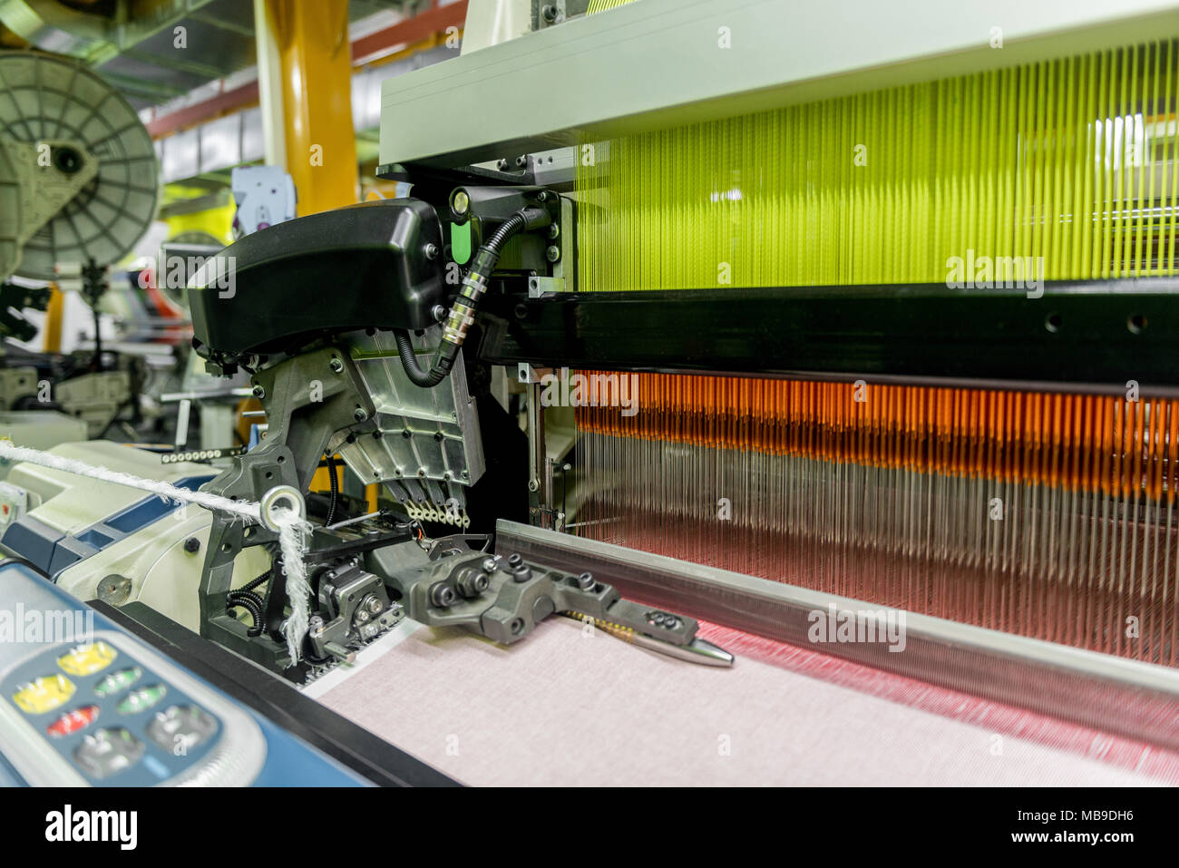 À tisser dans une usine de textile, gros plan de la ligne de production de tissus industriels. Banque D'Images